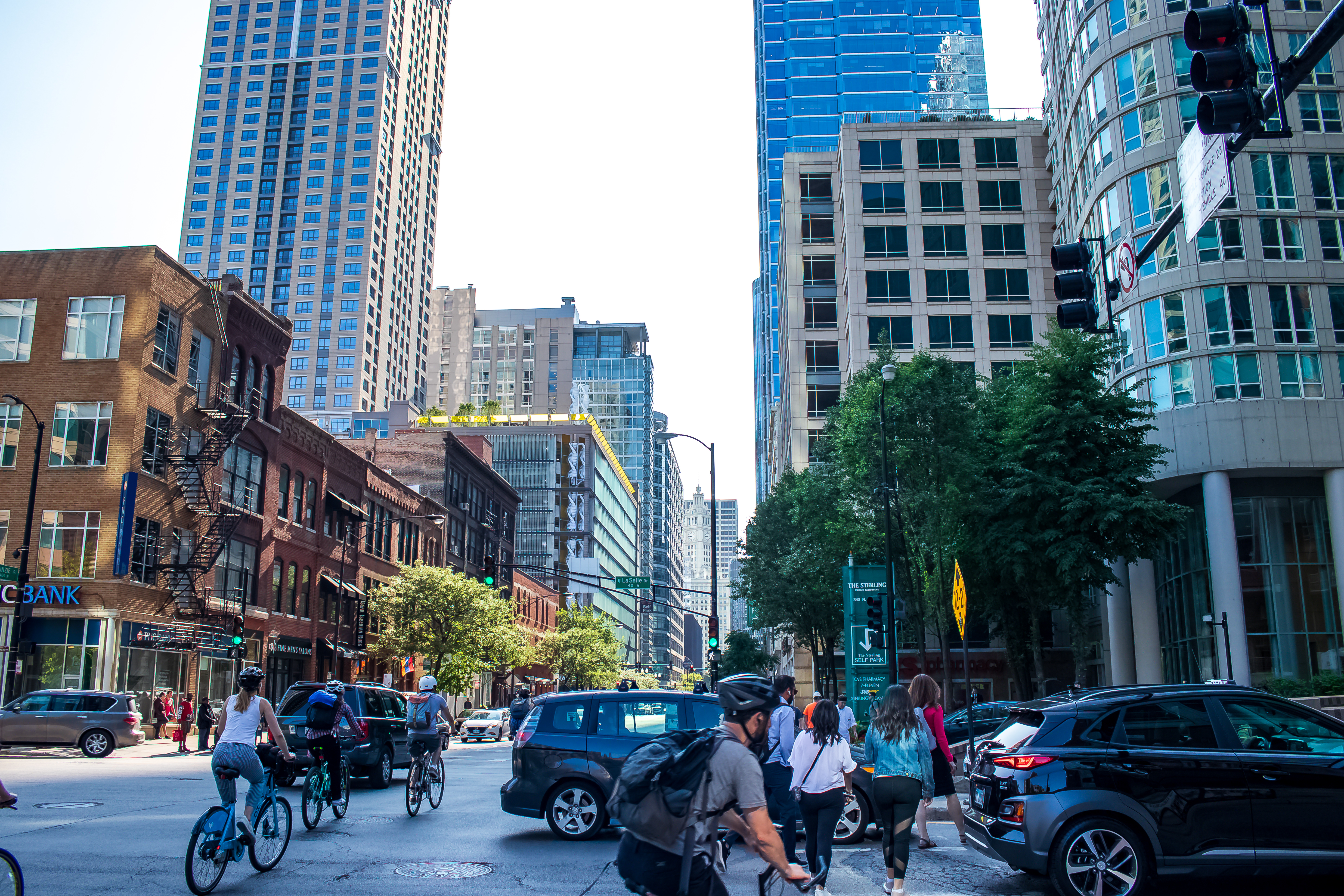 Bicyclists and pedestrians maneuver among traffic on a busy city street