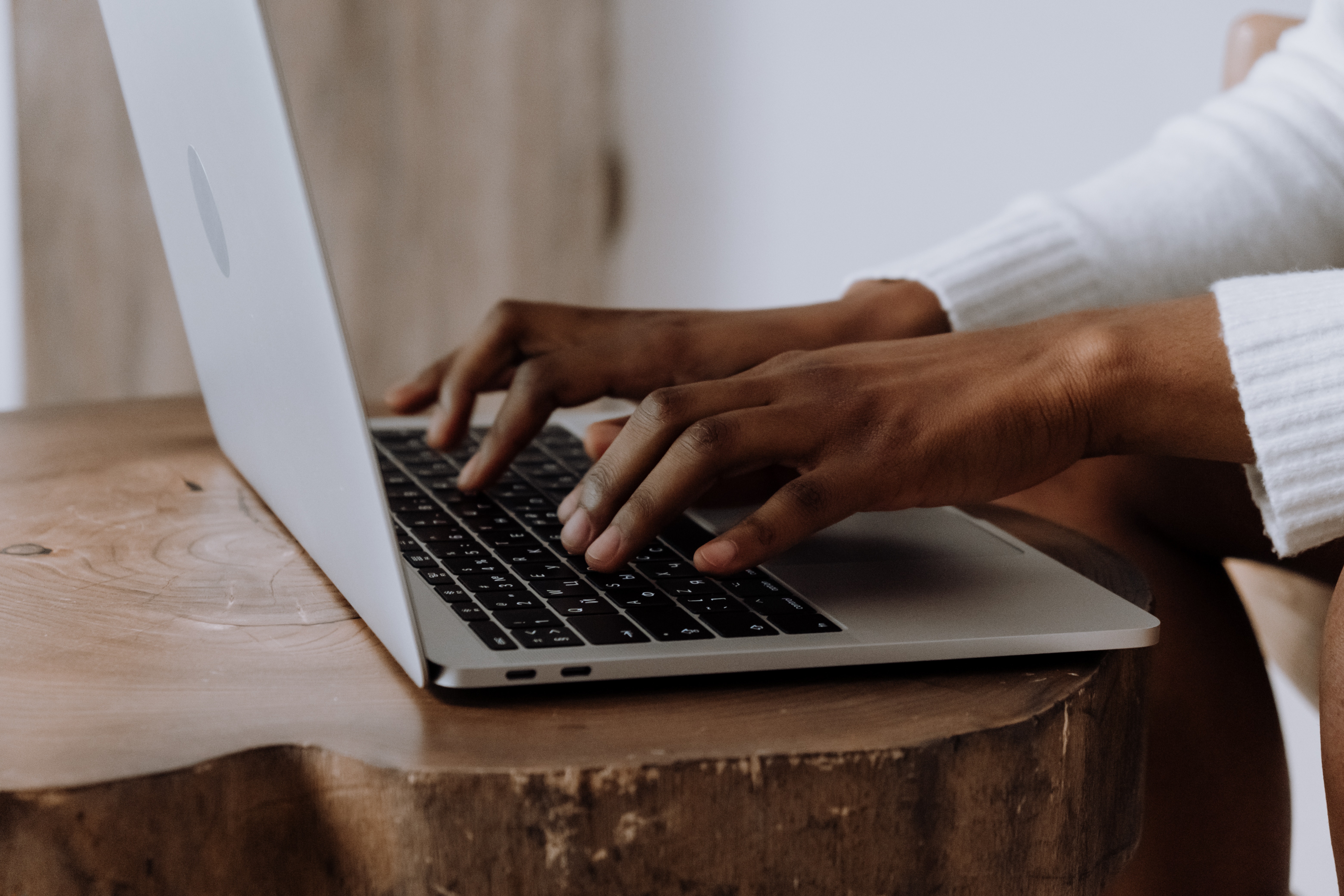 Hands typing on a laptop keyboard.