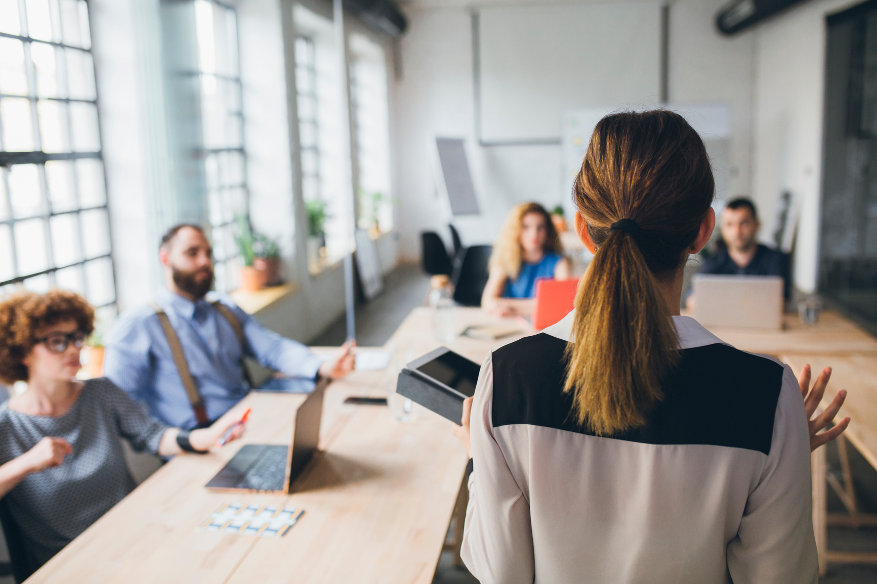 Woman presenting in fornt of a group of business people.