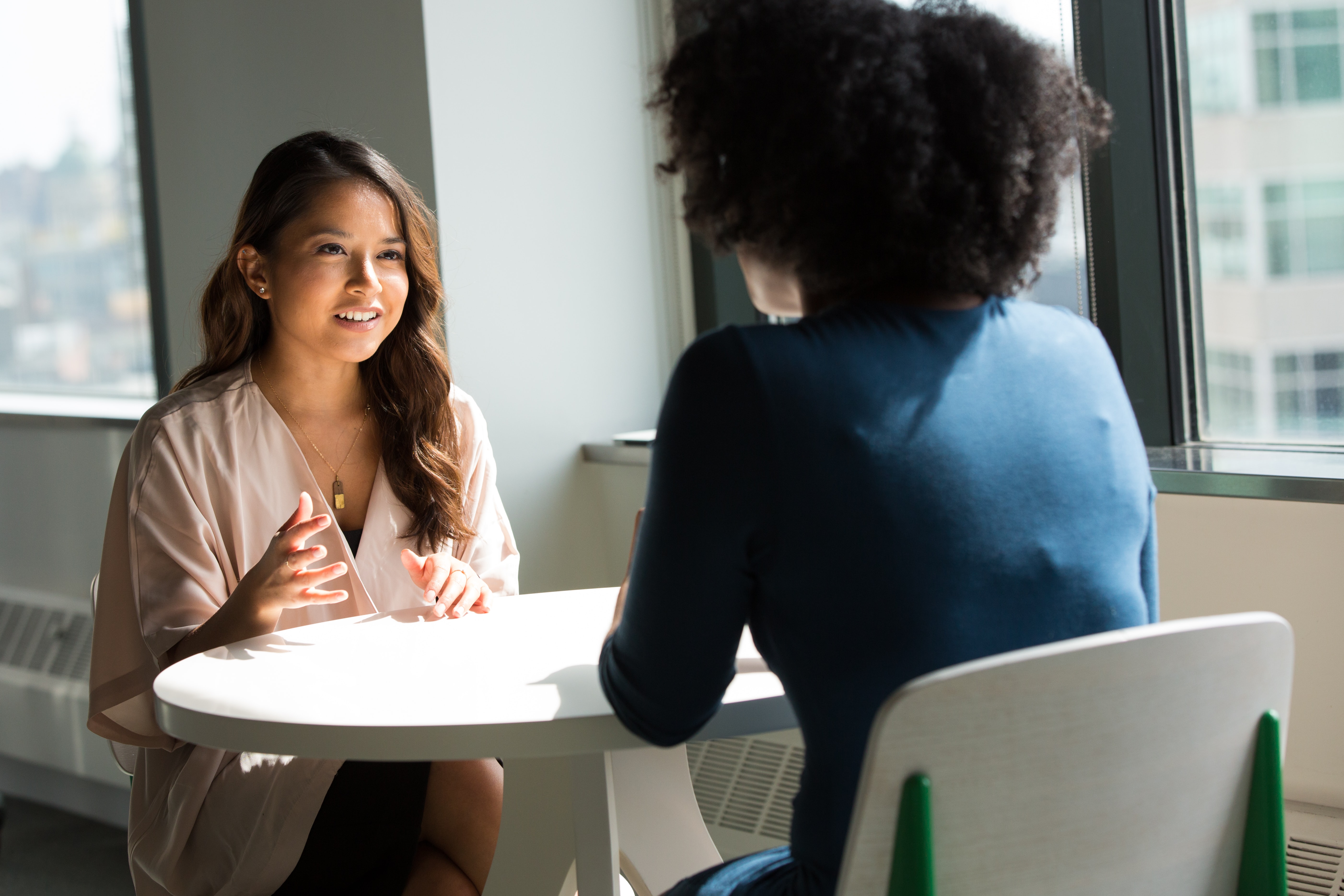 Two women having a serious discussion at a table.