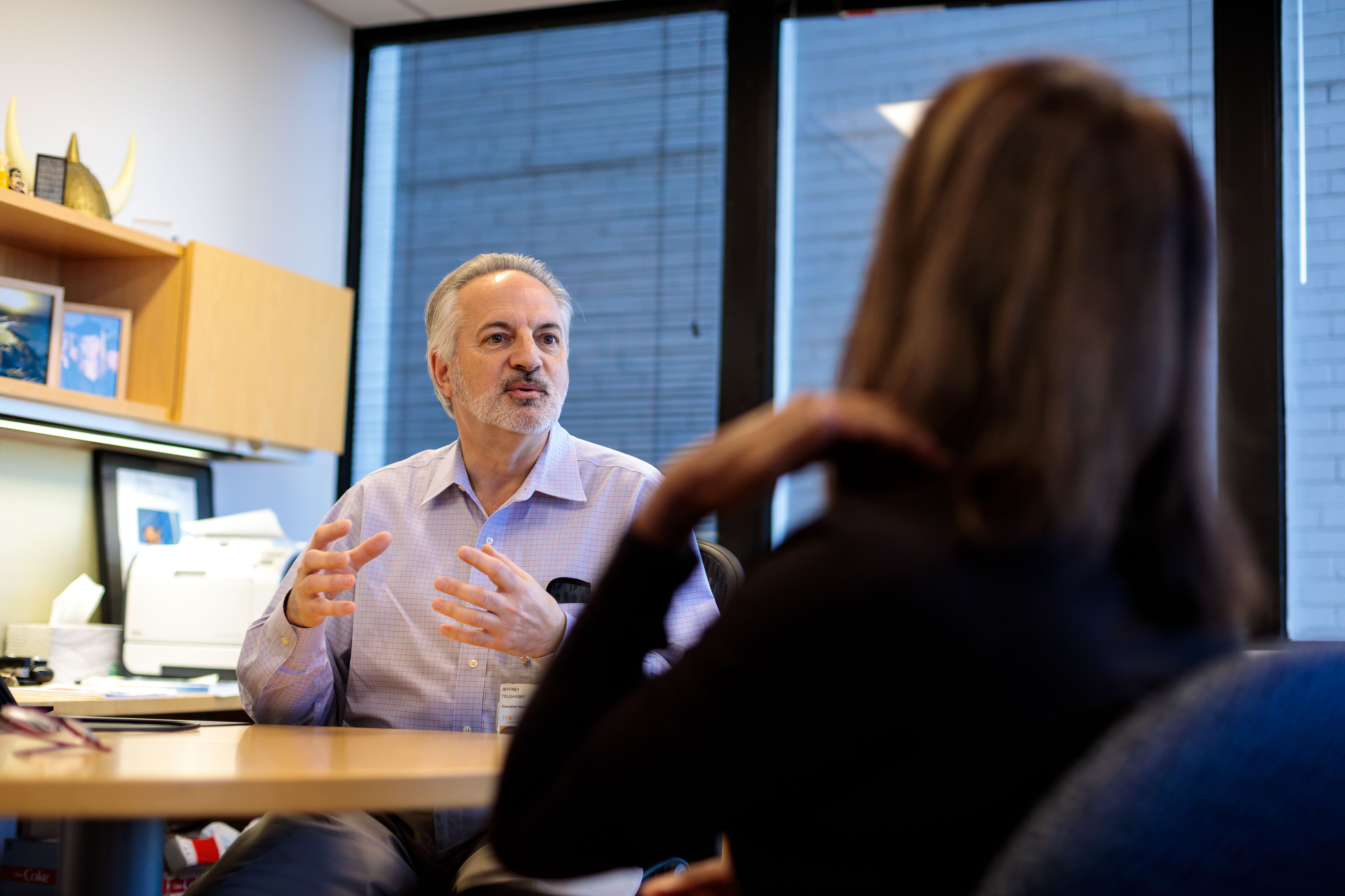 A gentleman having an animated conversation with another person in an office.