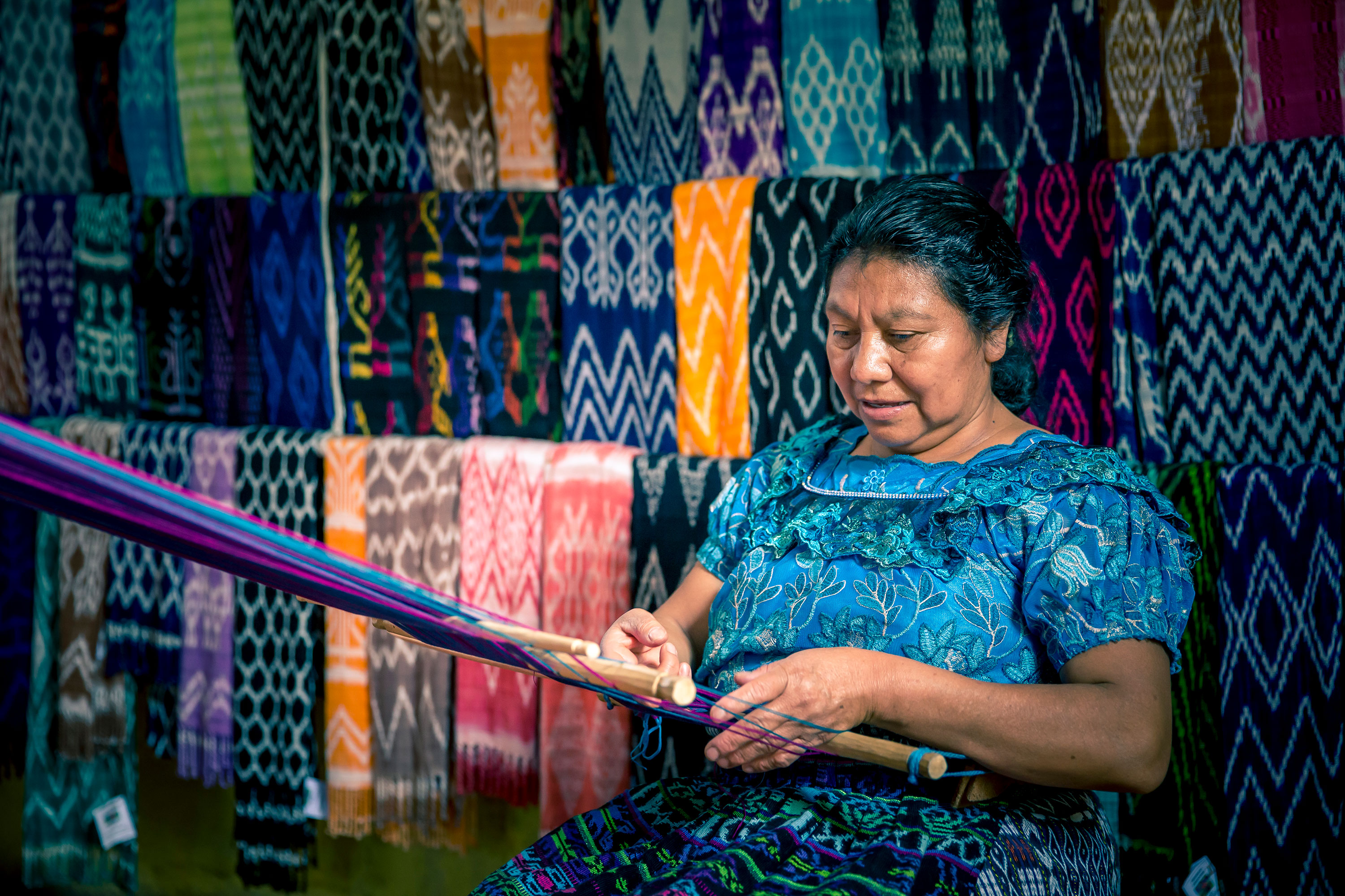 Woman weaving colorful rugs