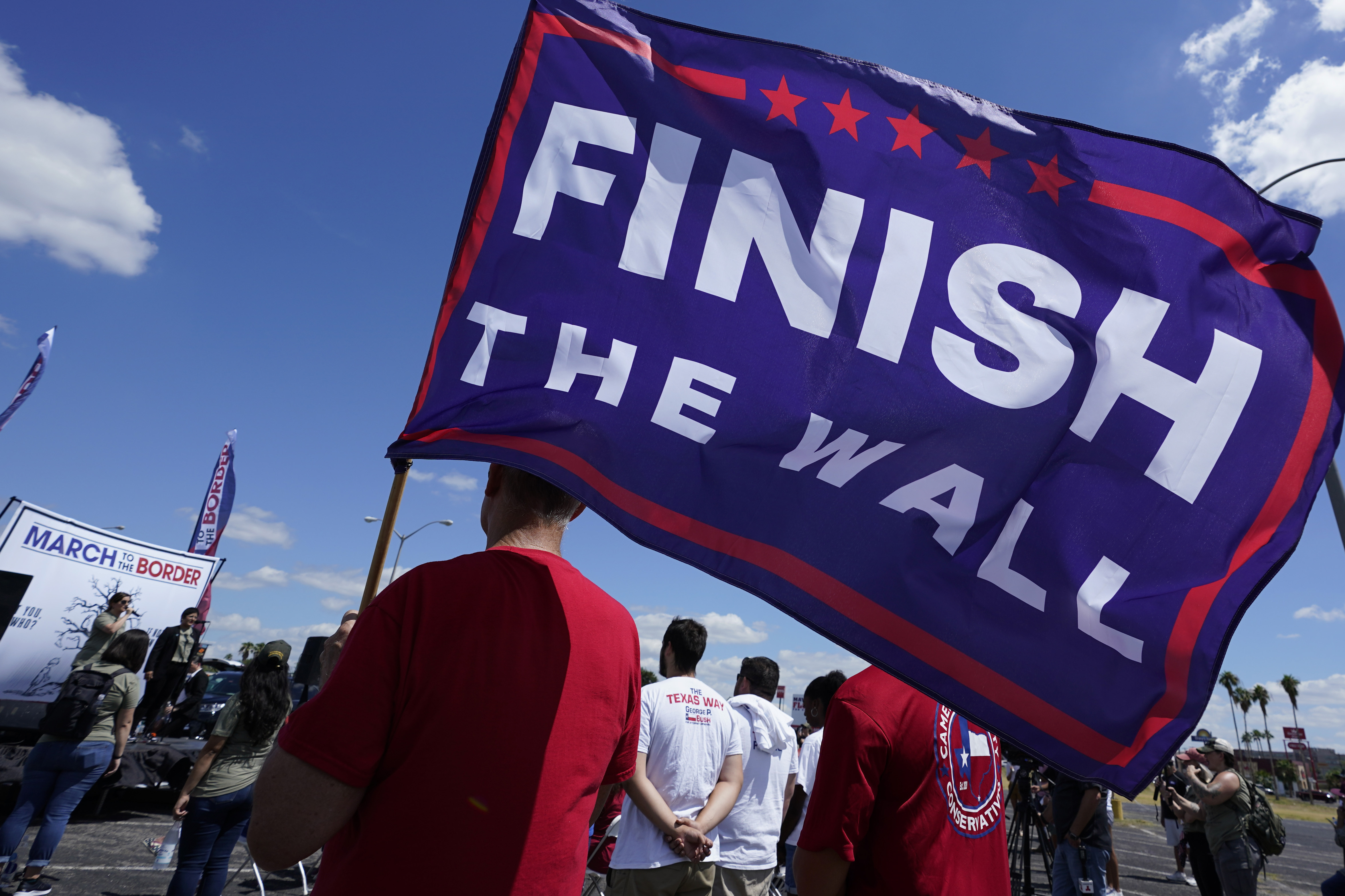 A participant holds a "Finish The Wall" flag at a March to the Border Rally, Saturday, Sept. 25, 2021, in McAllen, Texas. (AP Photo/Eric Gay)