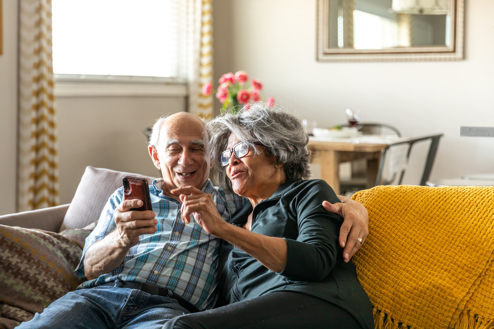 Couple looks at their phone and wife points.