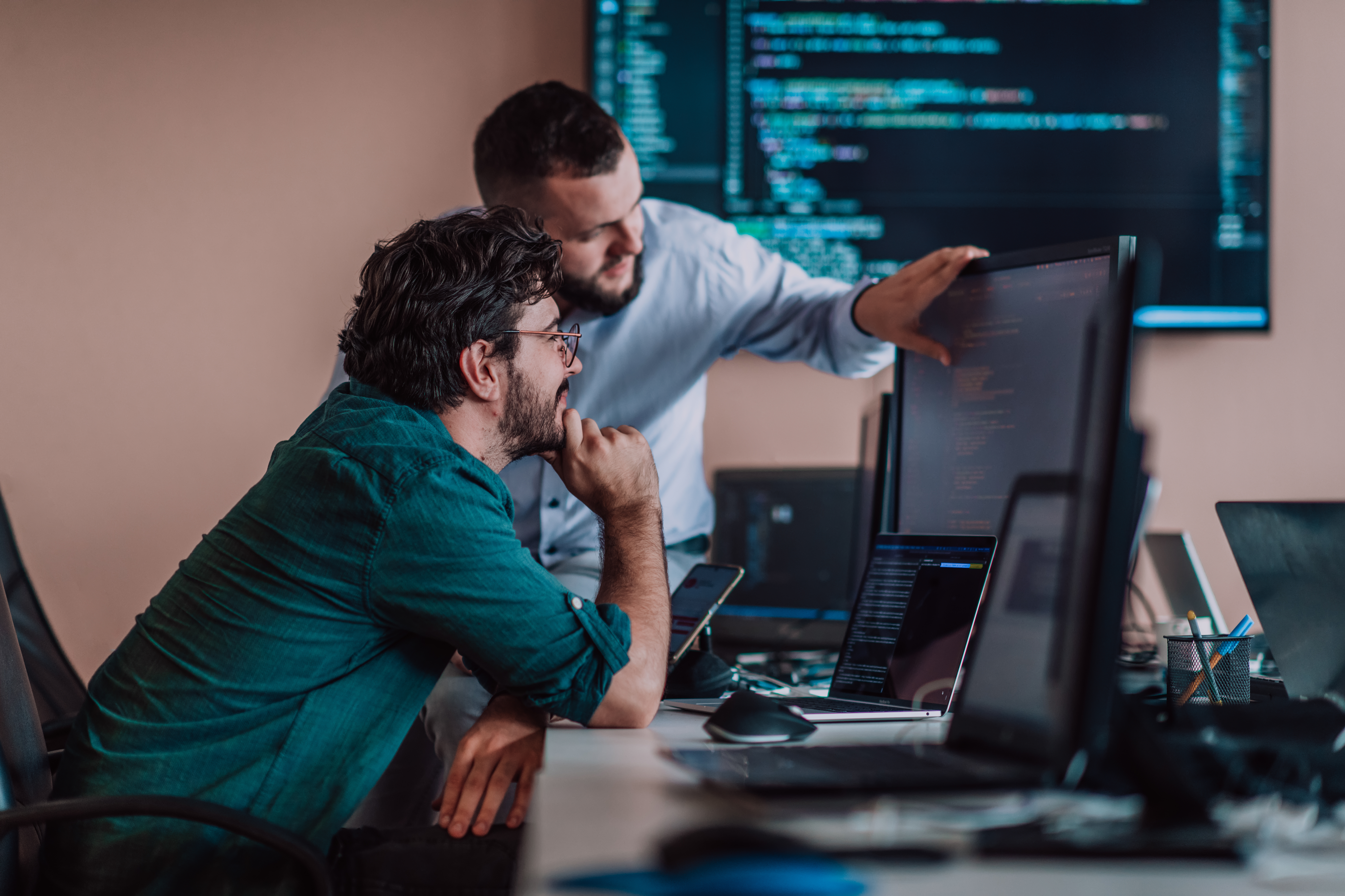 Programmers engrossed in deep collaboration, diligently working together to solve complex problems and develop innovative mobile applications with seamless functionality